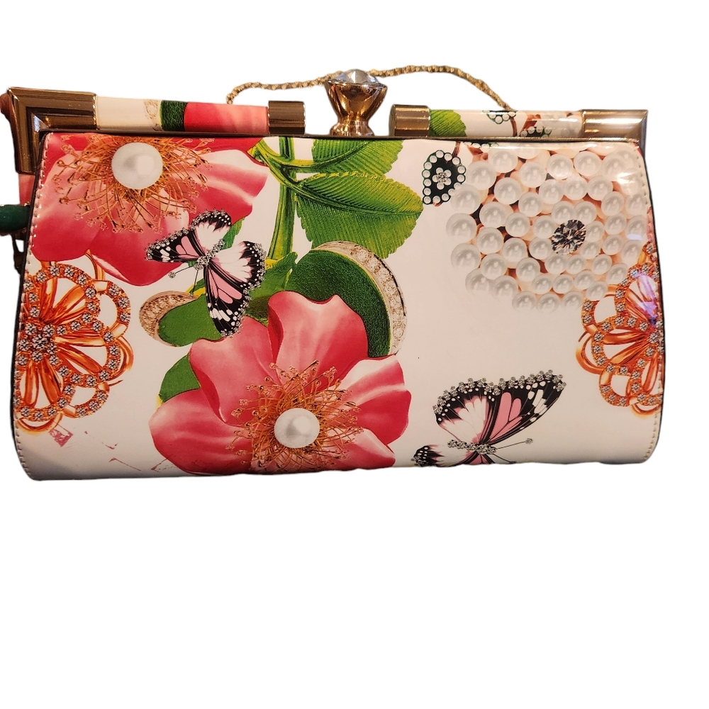 White floral bag. Can be carried as a clutch. Gold chain strap.